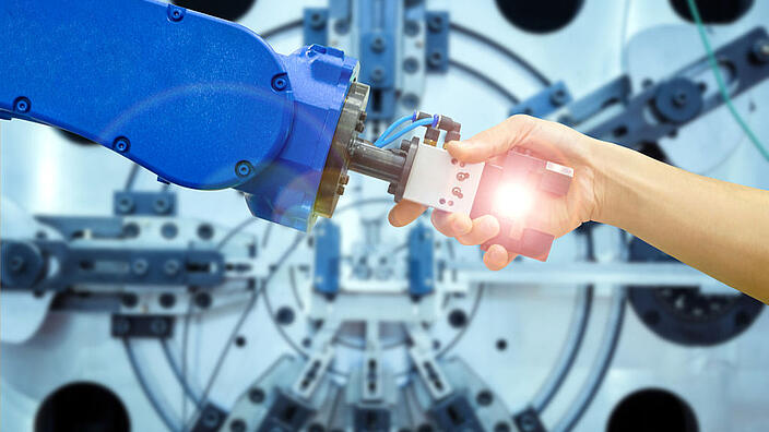 Industrial robot handshake with human on relationship for working on industrial manufacturing in concept industrial 4.0, on flare filter and blurred machinery working on blue tone background