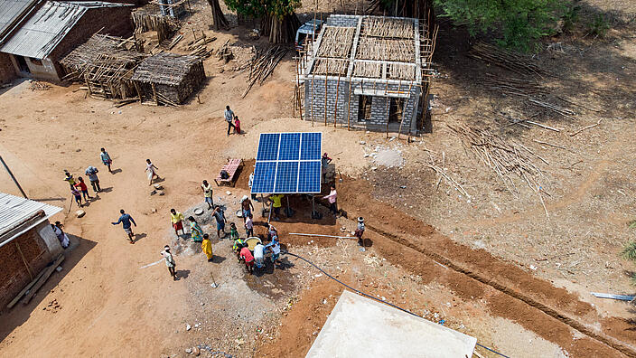 Aerial view of an African village, solar-powered well in the center